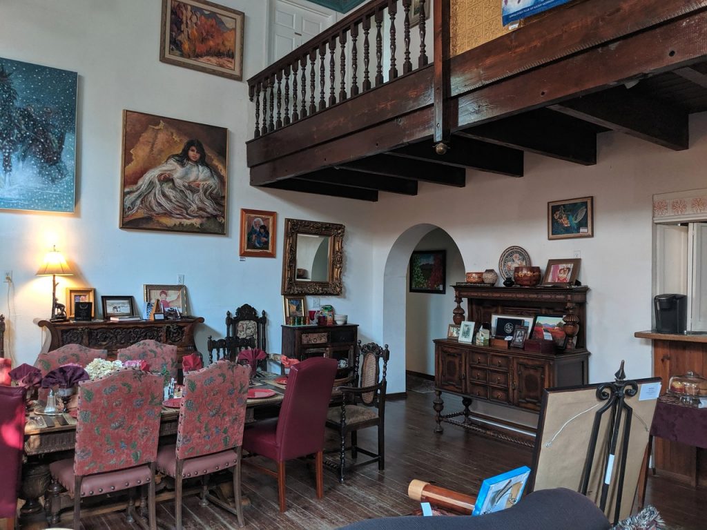 A dining table with red chairs and paintings on the wall of the Lundeen Inn