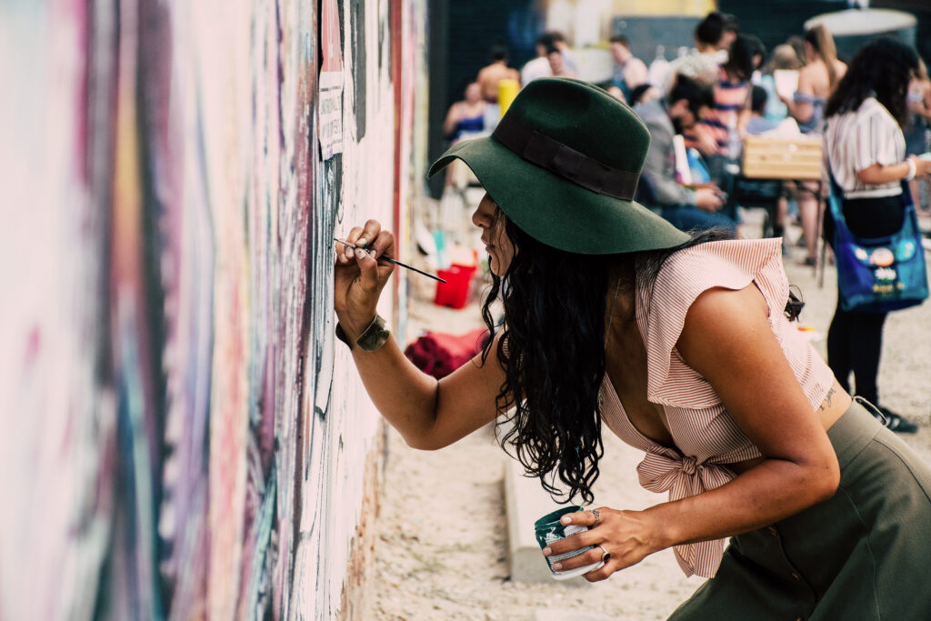 Woman painting on a building exterior
