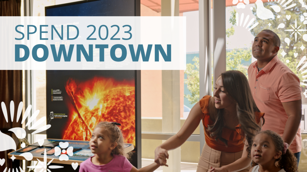 Spend 2023 downtown! A family walking into a science museum.